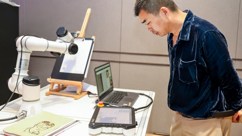 嘉賓體驗遨博AI繪畫機器人。主辦方供圖